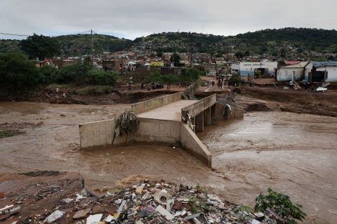 A river runs around a damaged bridge on April 12 after heavy rain destroyed it near Durban.